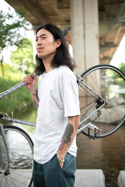 Photo young man holding his bike