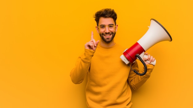 Young man holding a megaphone showing number one