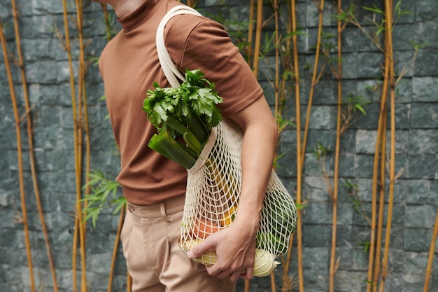 Young Man Holding Mesh Bag