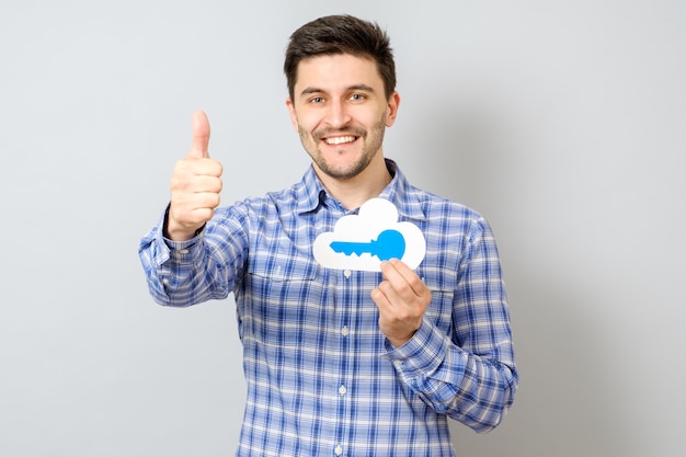 Young man holding model of cloud with blue key