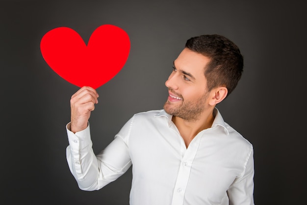 Young man holding paper heart