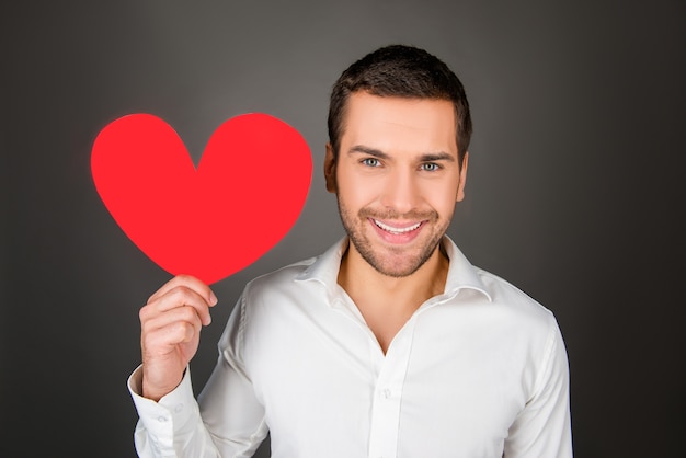 Young man holding paper heart