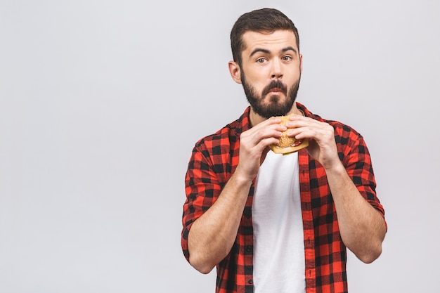 Giovane che tiene un pezzo di hamburger. concetto di dieta isolato su sfondo bianco.