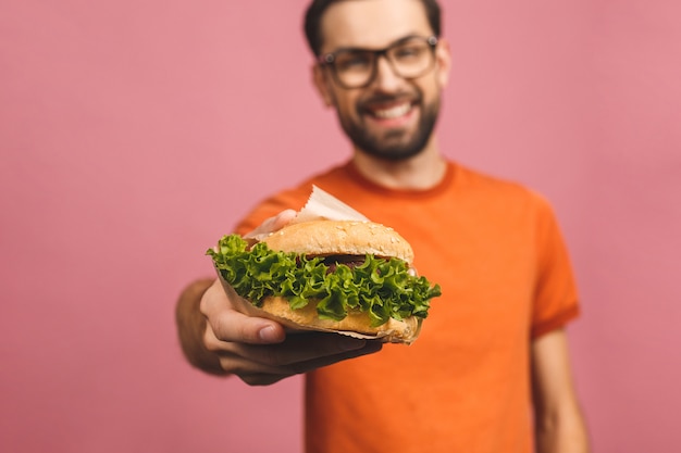 Young man holding a piece of hamburger