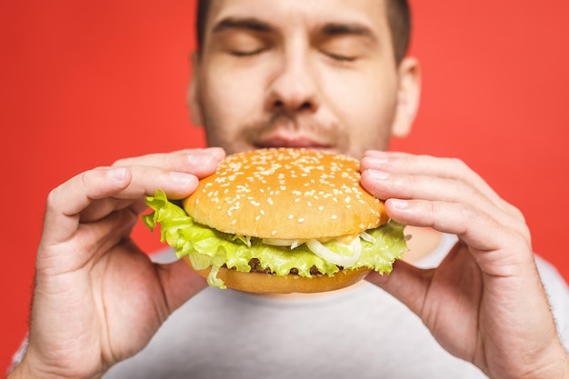 Young man holding a piece of hamburger