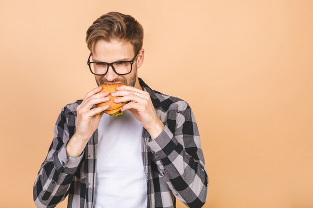 Young man holding a piece of hamburger