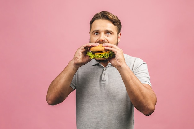 Young man holding a piece of hamburger