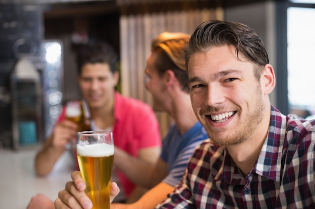 Young man holding pint of beer