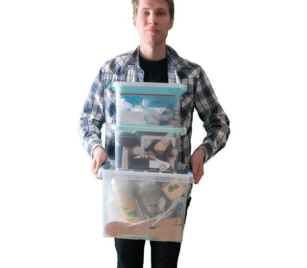 A young man holding a plastic box container with things stored inside, isolated white background