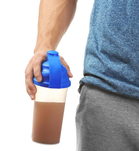 Young man holding protein shake on white background