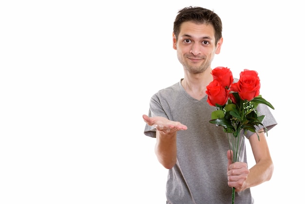 young man holding red roses while giving hand