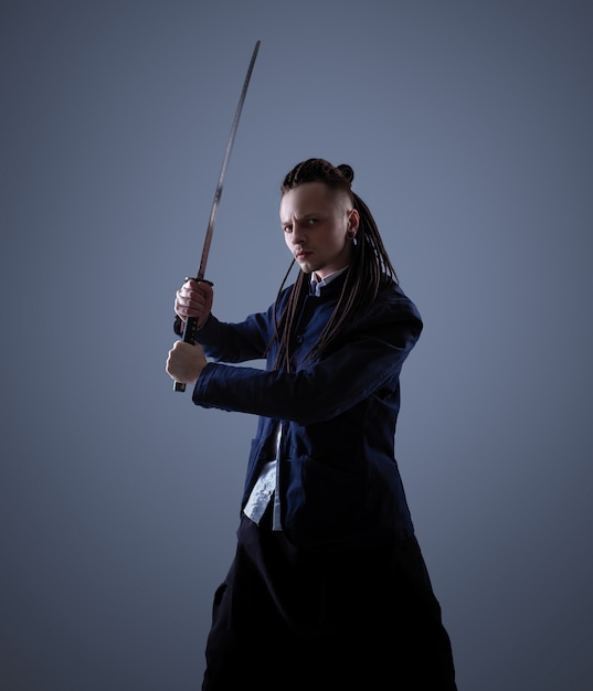 Young man holding a samurai sword. Glamour photo.