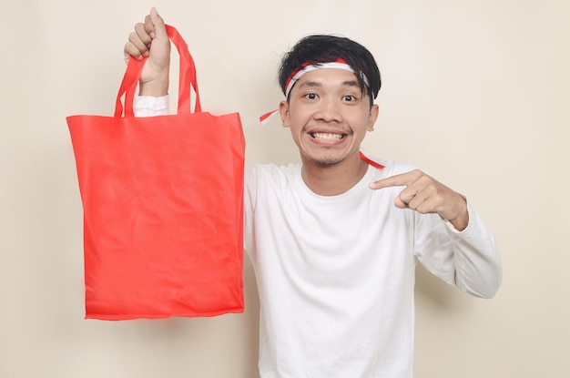 Young man holding shopping bags on isolated background Independence day discount concept