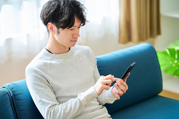 Photo スマートフォンを持った若い男