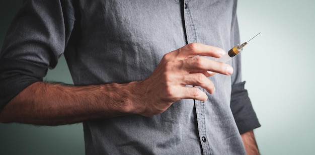 Young man holding a syringe in her hand