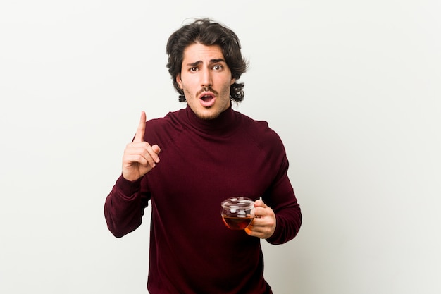 Young man holding a tea cup having an idea, inspiration concept.