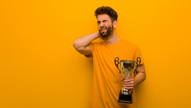 Photo young man holding a trophy suffering neck pain