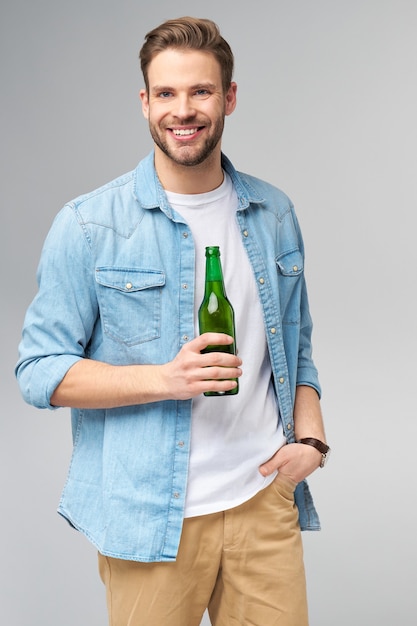 Young Man holding wearing jeans shirt Bottle of beer standing