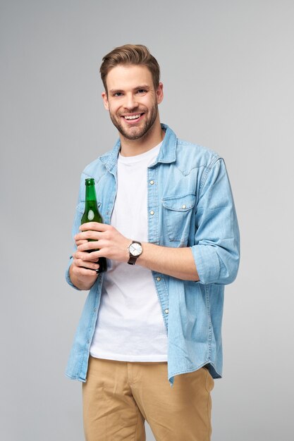 Young Man holding wearing jeans shirt Bottle of beer standing