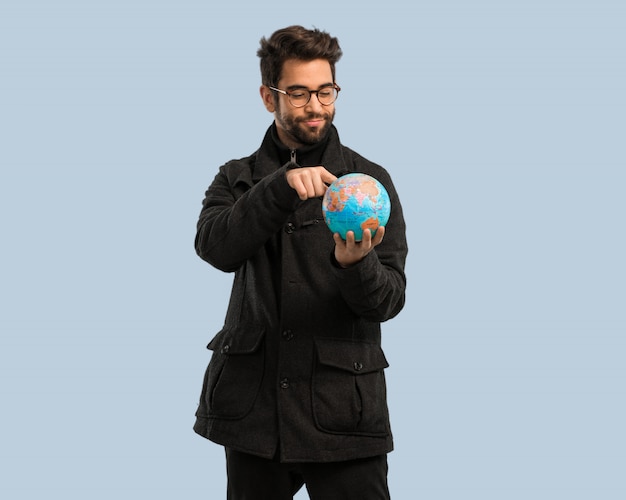 Young man holding a world globe