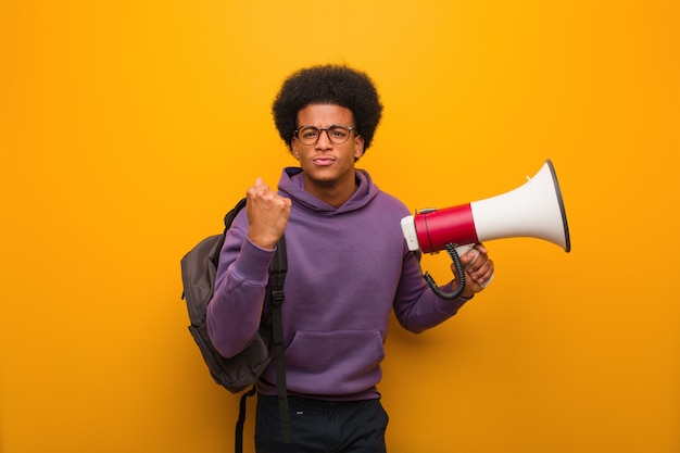 Photo young man holdinga a megaphone showing fist to front, angry expression