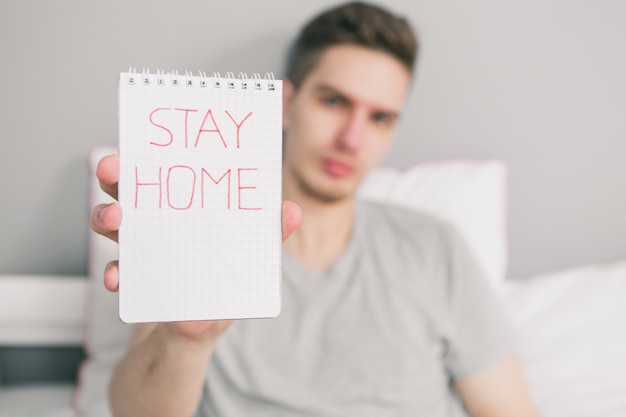 Young man holds in his hands stay home