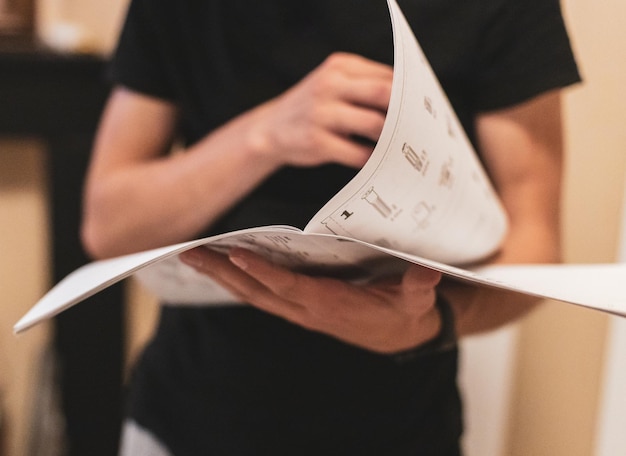 A young man holds an instruction paper in his hands