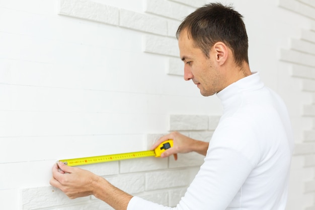 a young man holds a level for a brick