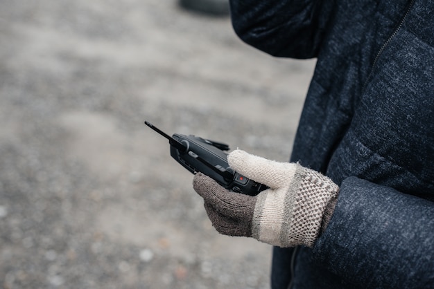 A young man holds a remote control for controlling a copter.