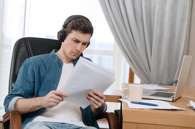 Young man in home office looking at the documents with concern