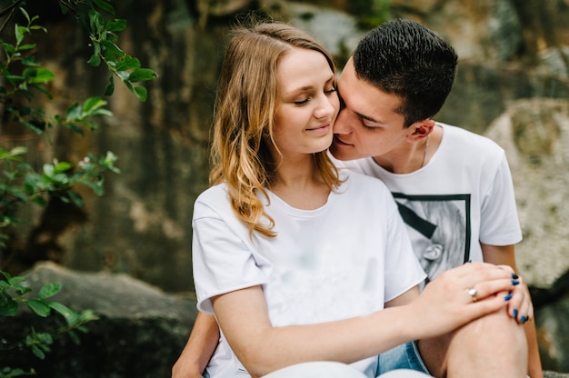 A young man hugs and kisses a girl