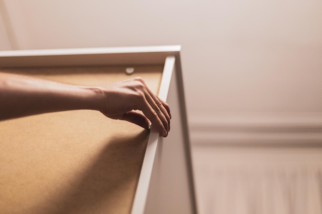 A young man installs rivets on a wardrobe