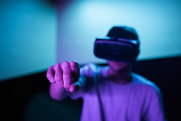 Young man interacting in a digital world using virtual reality headset with motion tracking tech