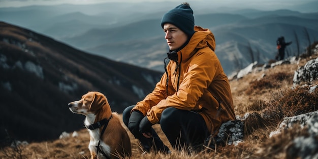 若い男が犬と一緒に山でハイキングしている