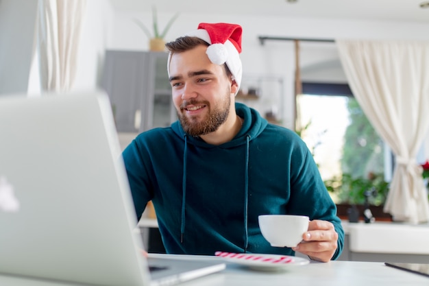 Young man is looking for Christmas gift in Internet