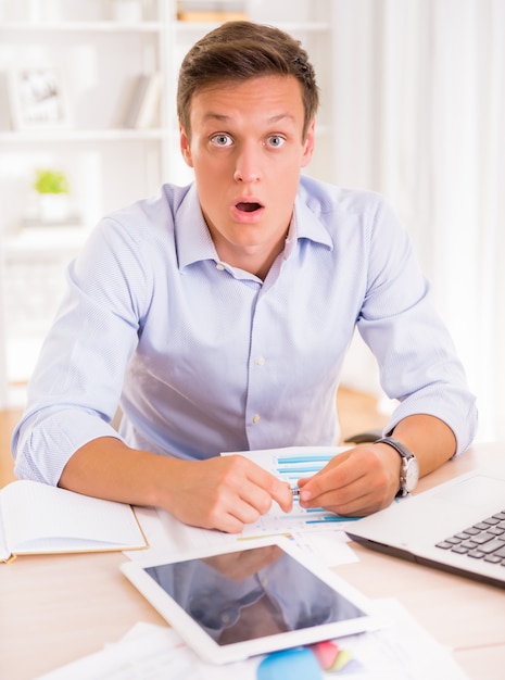 Young man is open his mouth and looking at the camera.