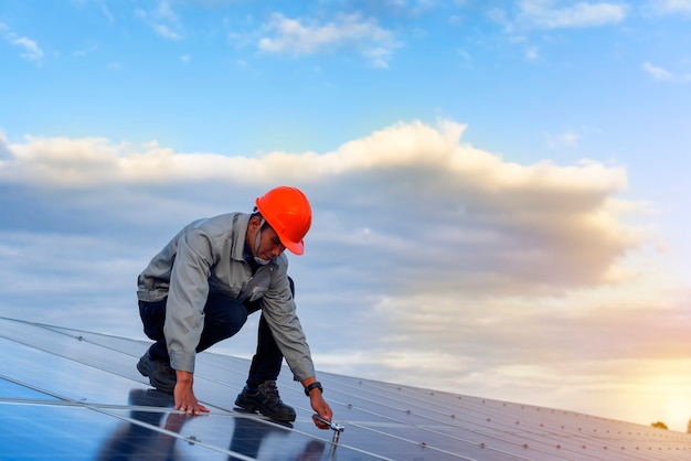 Photo the young man is repairing the solar panel at the station.