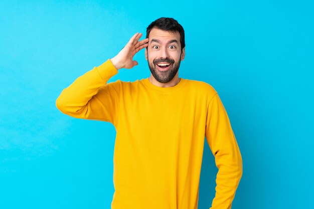 Young man over isolated blue wall has just realized something and has intending the solution