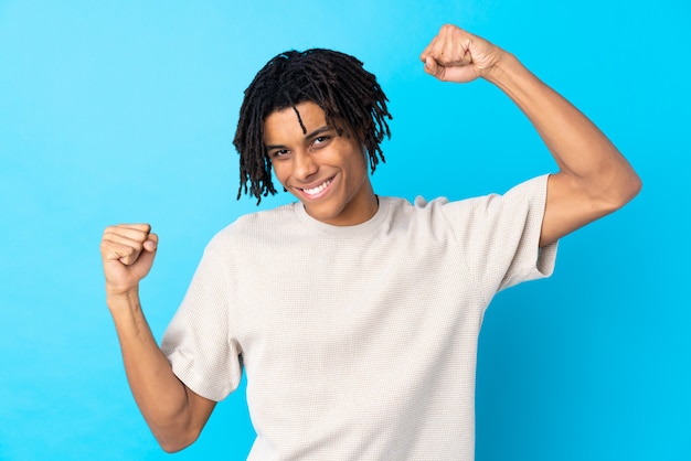 Young man over isolated blue wall