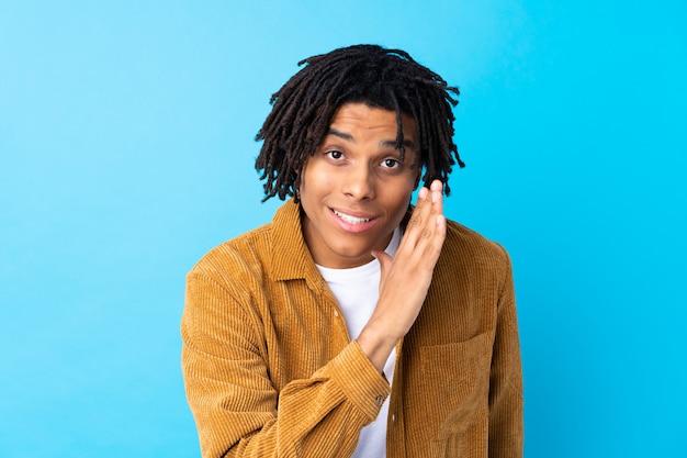 Young man over isolated blue wall