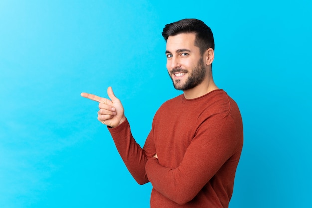 Young man over isolated blue wall