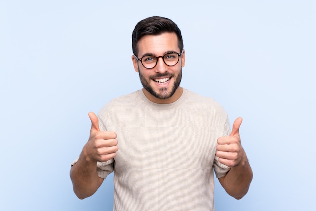 Young man over isolated blue wall