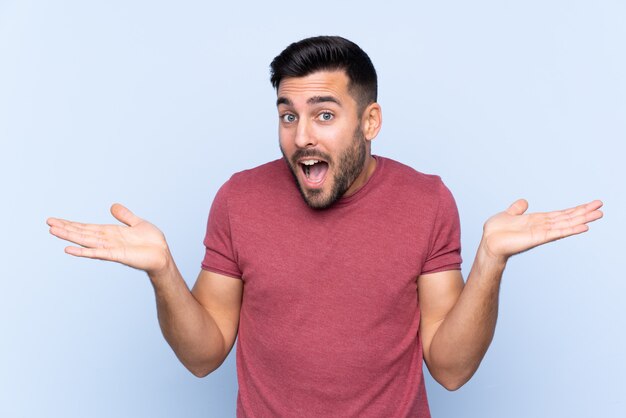 Young man over isolated blue wall