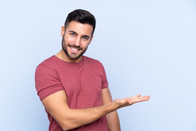 Young man over isolated blue wall