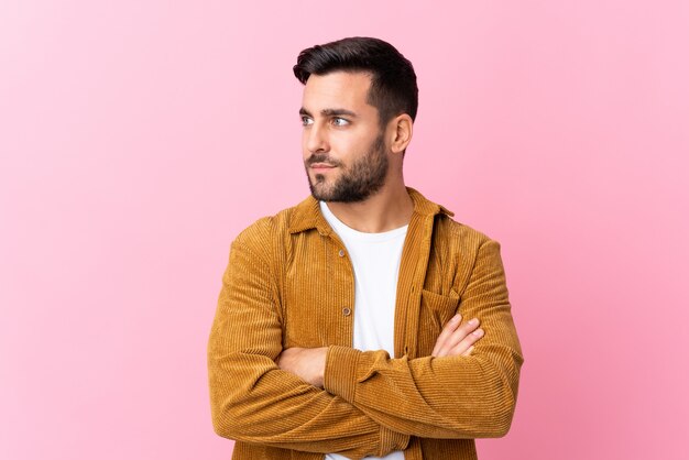 Young man over isolated pink wall