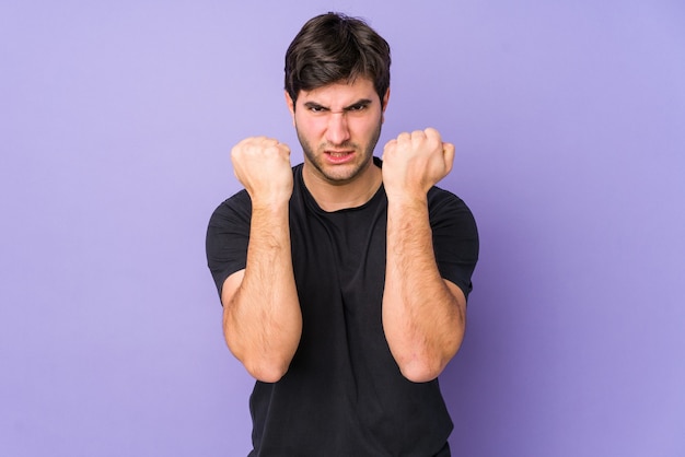 Young man isolated on purple upset screaming with tense hands.