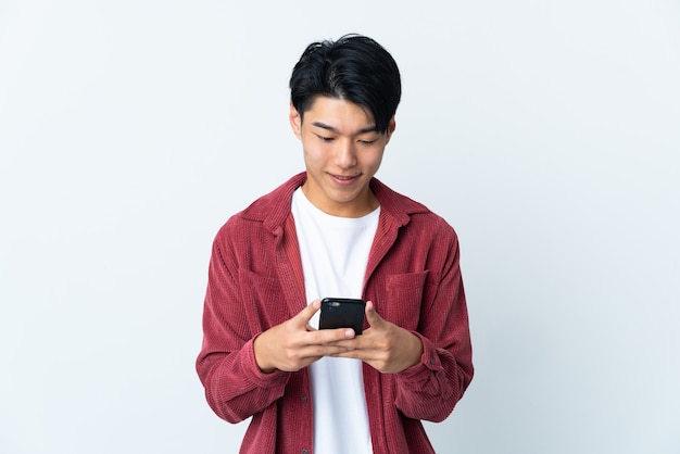 Young man isolated sending a message or email with the mobile