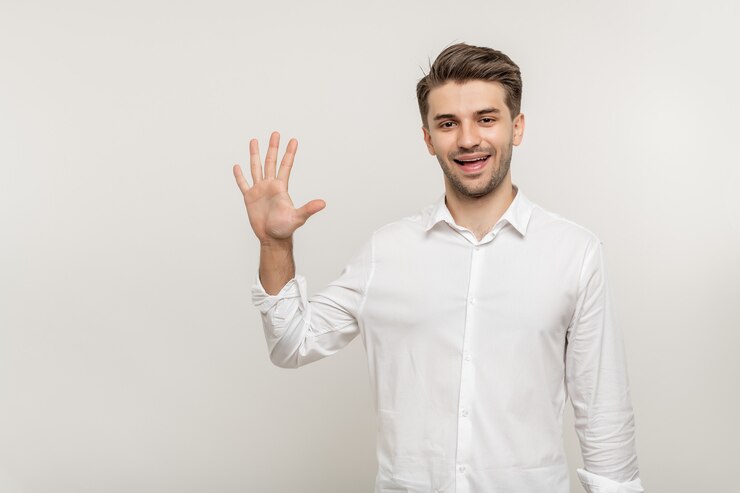 Photo 孤立した白い背景の上の若い男は、白の上に孤立した笑顔で5本の指を示しています