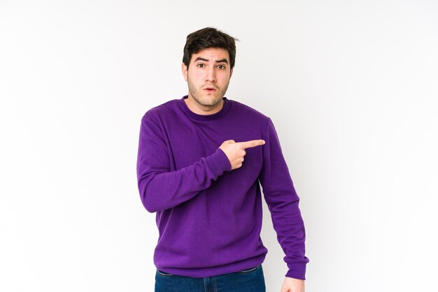 Young man isolated on white pointing to the side