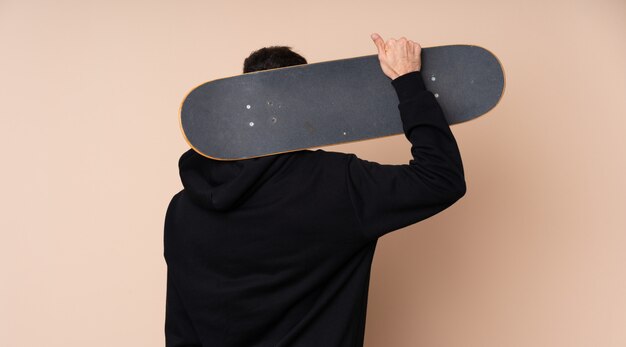 Young man over isolated with a skate in back position